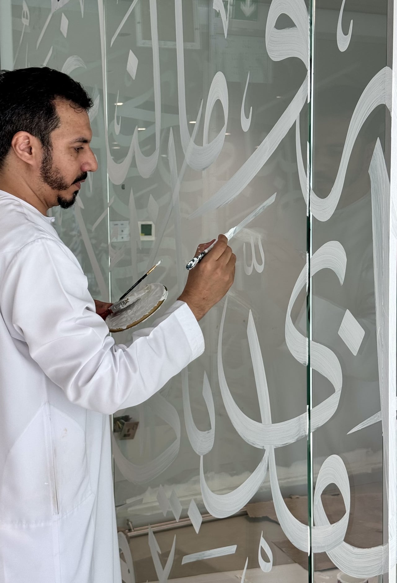 الفنان يكتب بالفرشاة مباشرة على الزجاج